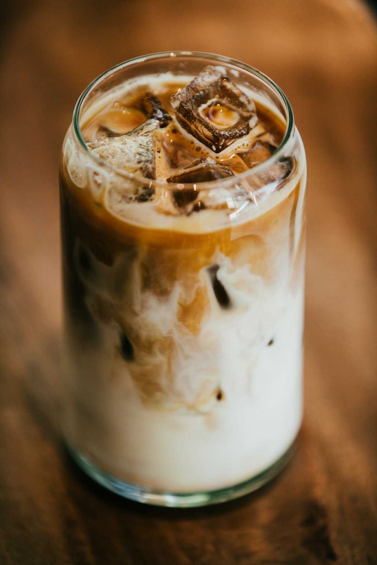 An iced coffee on a wooden table in warm light