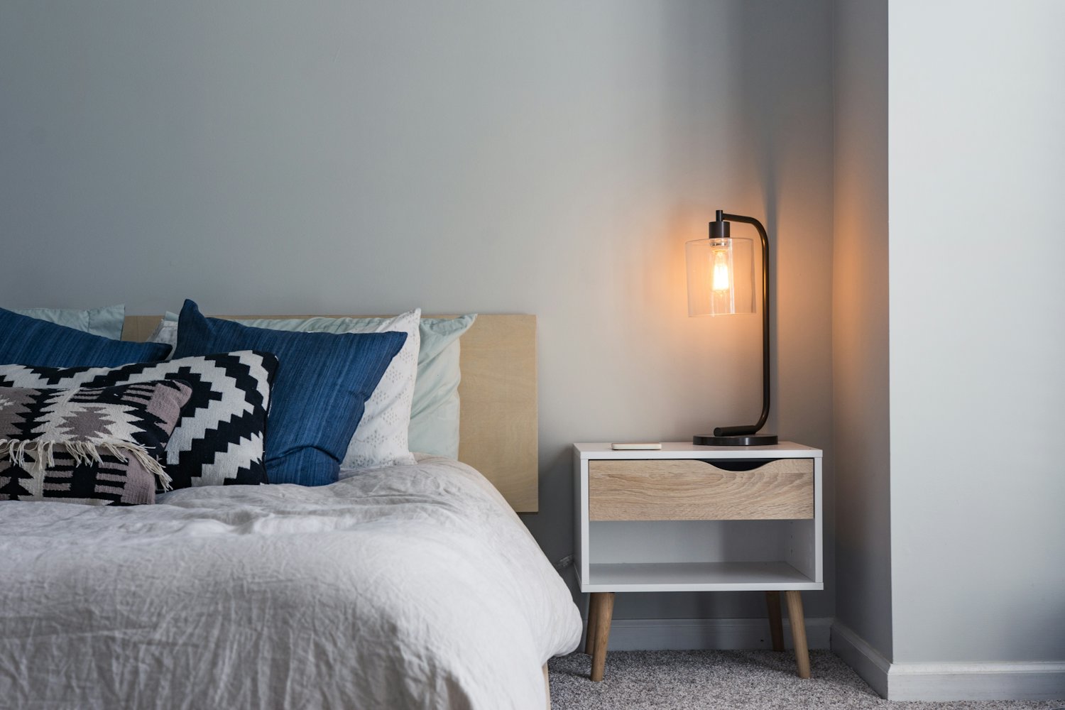 Family Room — a bright bedroom corner with soft linen and a warm bedside light